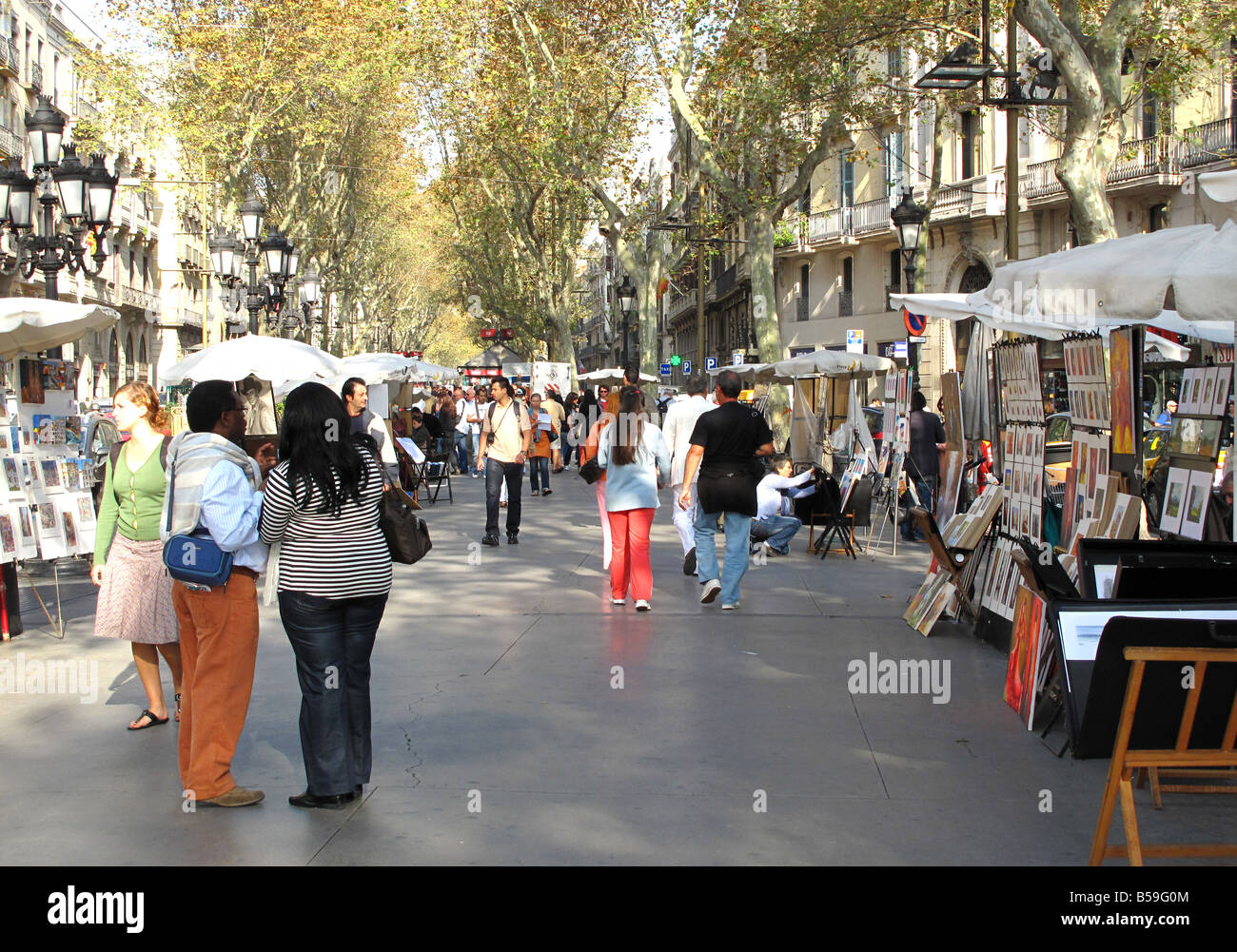 I turisti alla ricerca di artisti di strada in una giornata di sole su La Rambla, Barcelona, Spagna Foto Stock