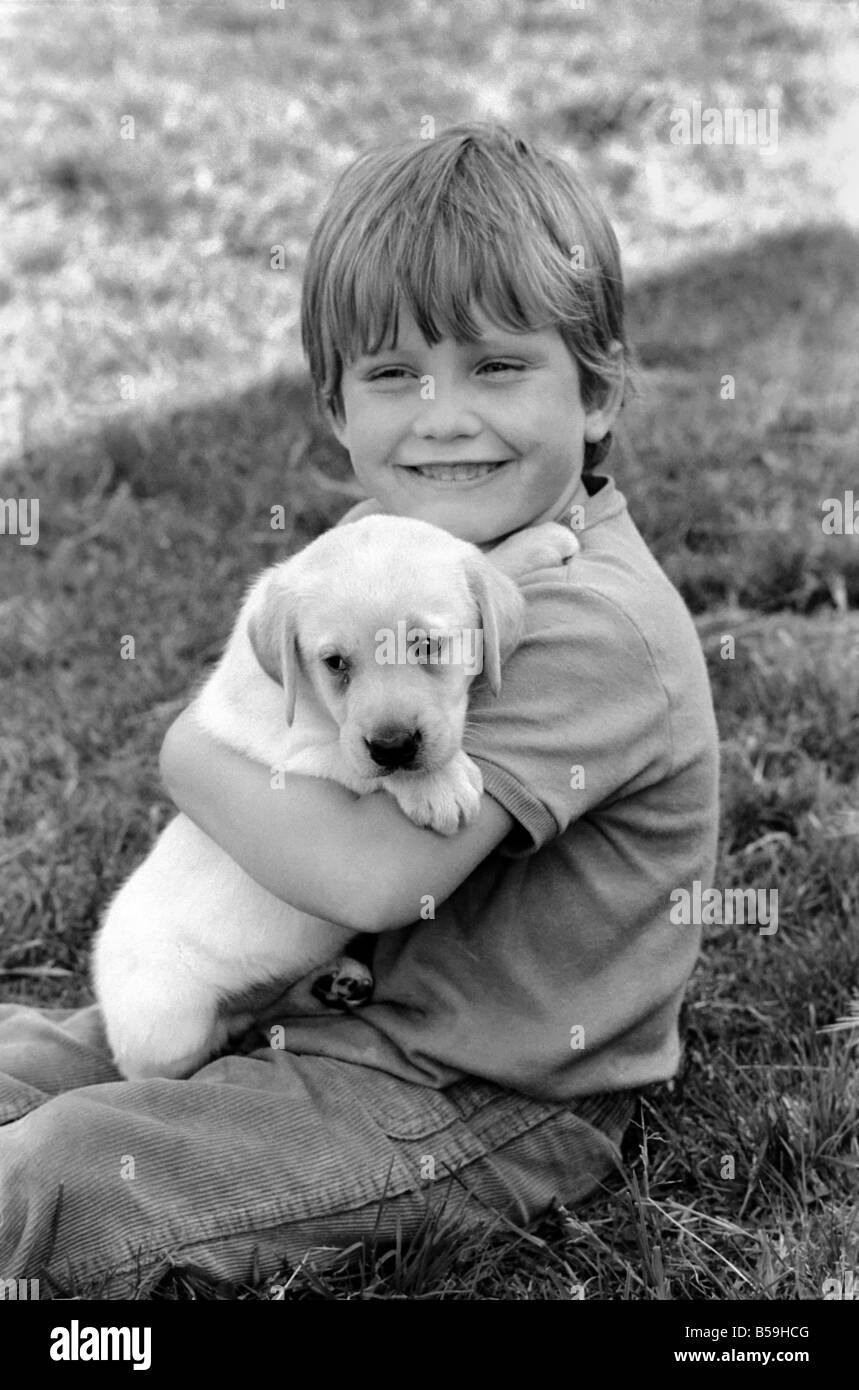 Un giovane ragazzo con un cucciolo di Labrador a Frant cucce in York vicino a Tonbridge che hanno tutti i tipi di cuccioli e cani in stabilimento. Essi sono tutti pedigree. Agosto 1977 77-04328-006 Foto Stock