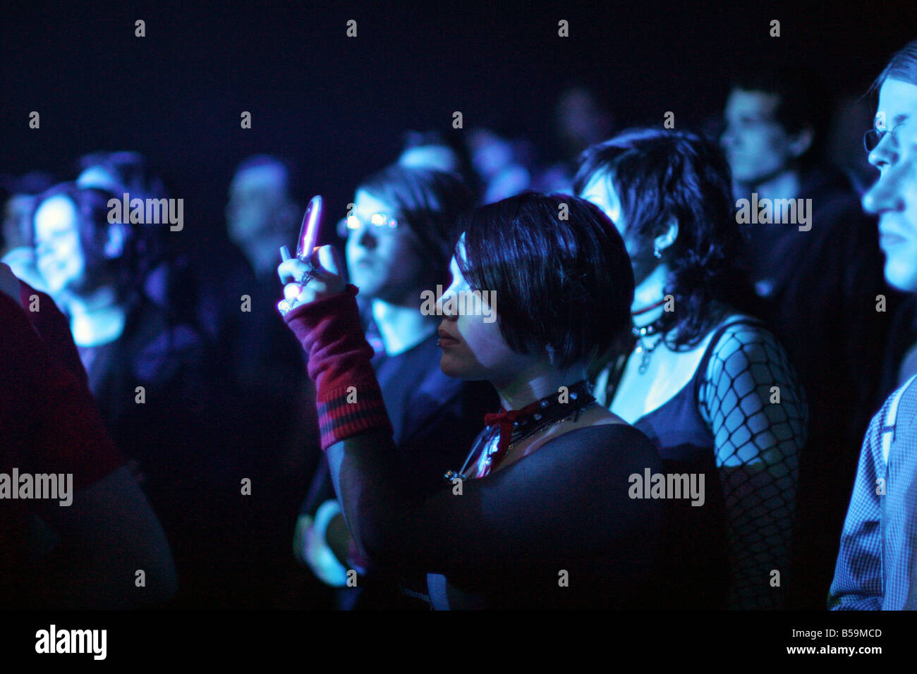 Ragazza facendo una foto con mobile durante il concerto Foto Stock