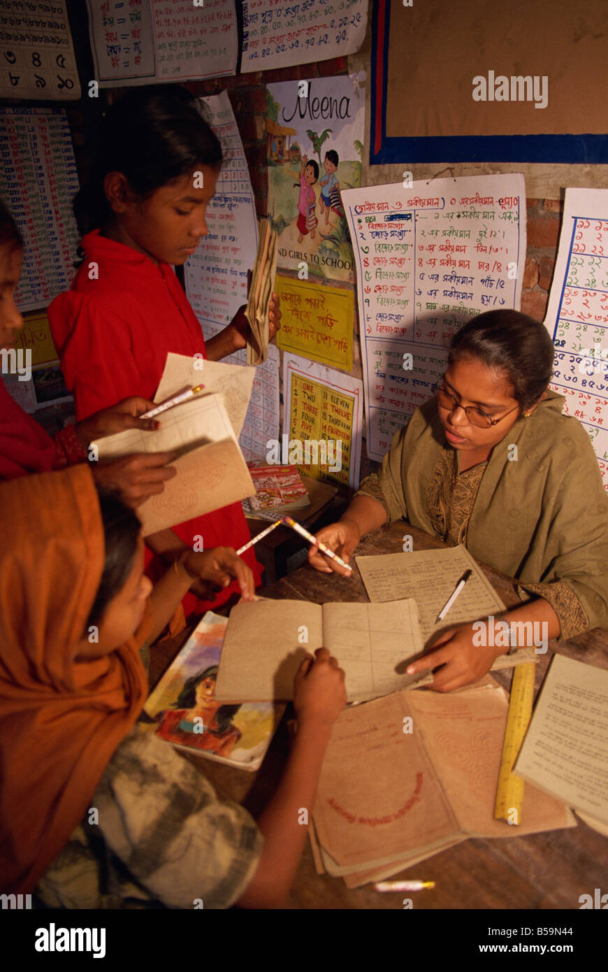 I contrassegni degli insegnanti studenti libri in una scuola negli slum di Dacca in Bangladesh Asia L TAYLOR Foto Stock