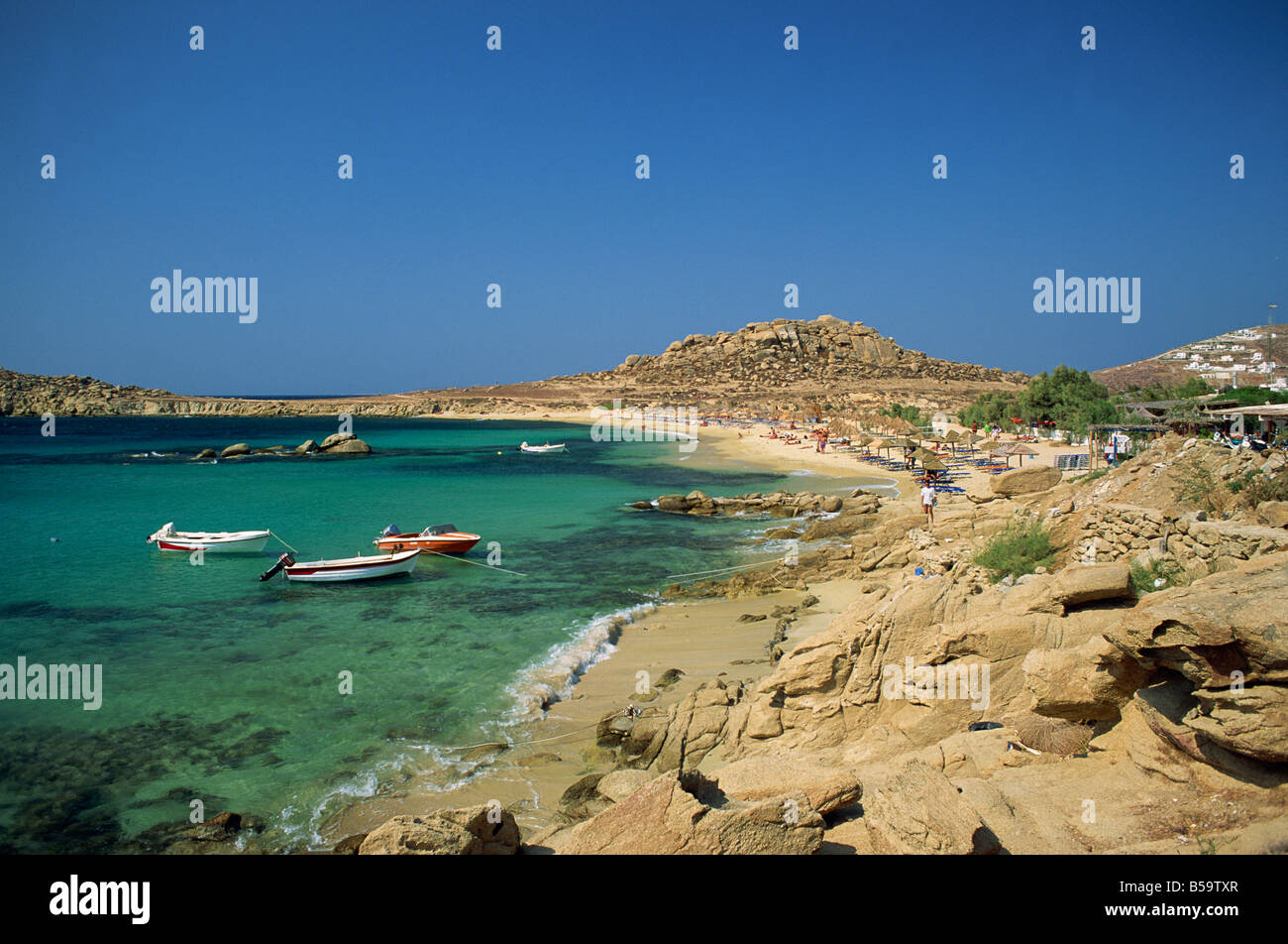 Costa rocciosa con imbarcazioni offshore a Piranga Beach Mykonos Cicladi Grecia F Hall Foto Stock