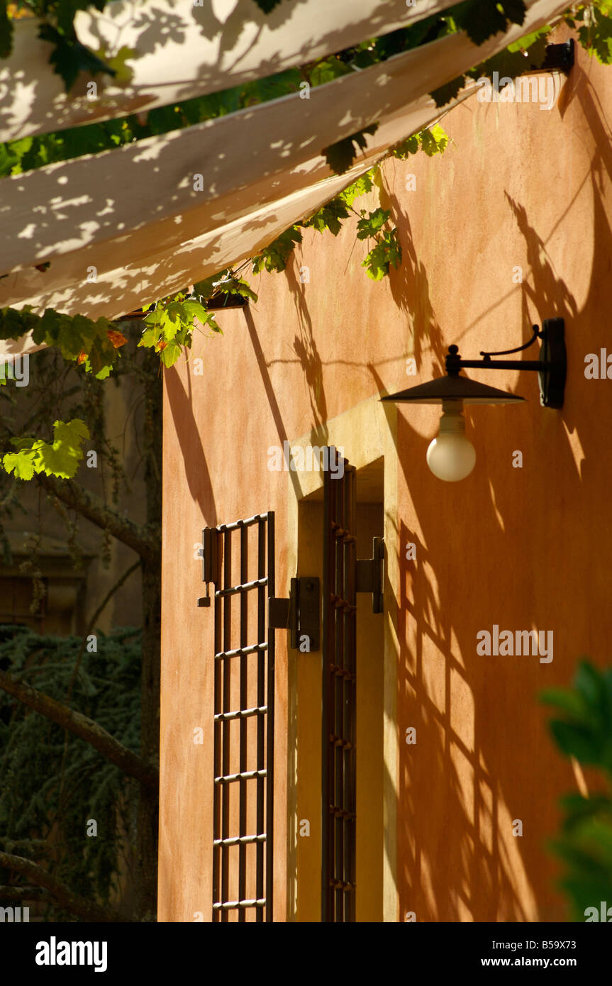 Entrata posteriore di una villa toscana con vitigni di drappeggio dal cielino Foto Stock