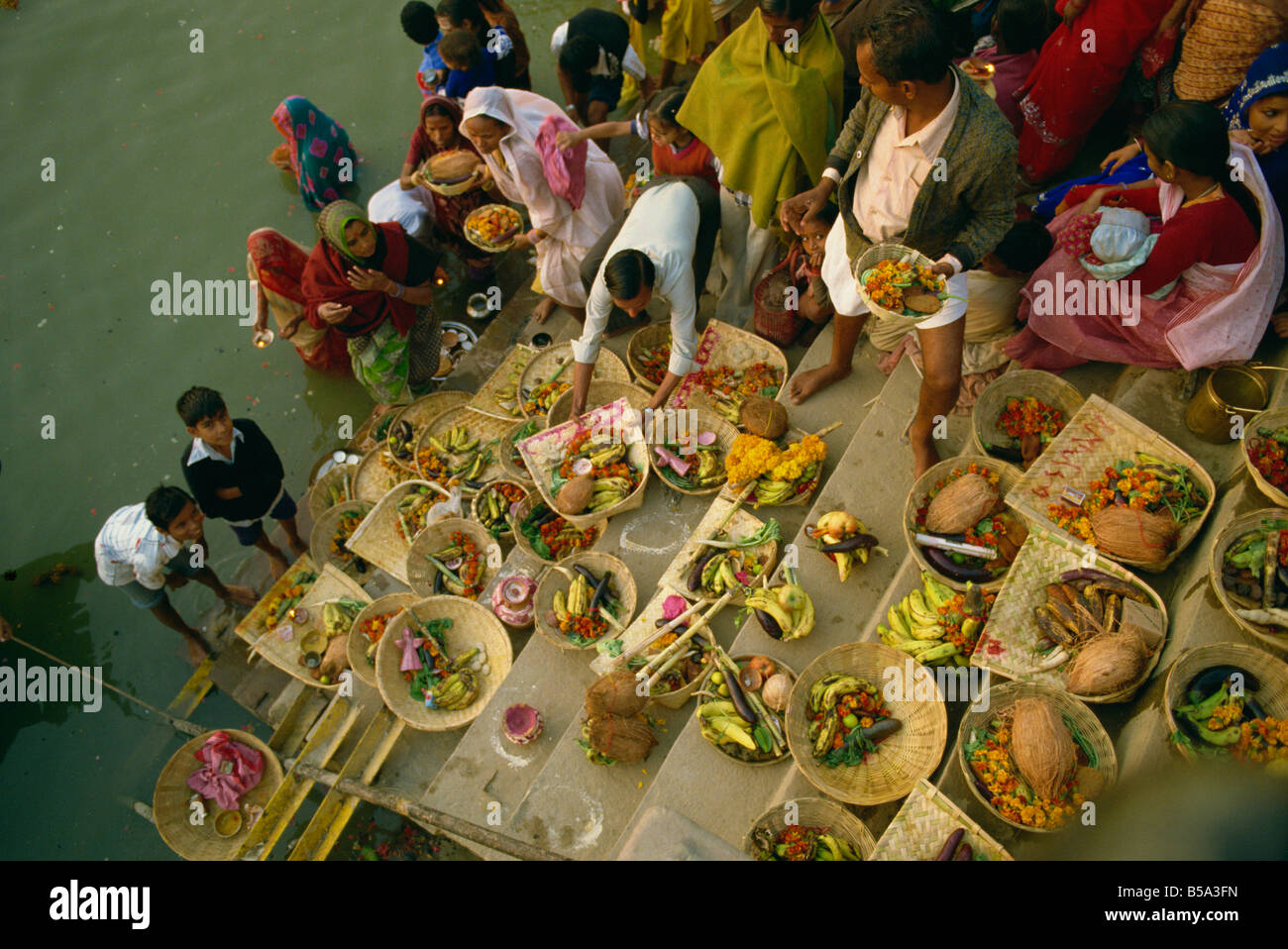 Offerte per il dio del sole Surya sul ghats durante il culto di Sun Festival Varanasi nello stato di Uttar Pradesh India Asia Foto Stock