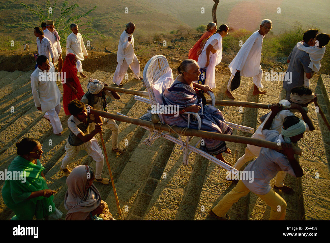 Jain pellegrini in cammino e di essere portato fino la collina sacra di Palitana nello Stato di Gujarat India Asia Foto Stock