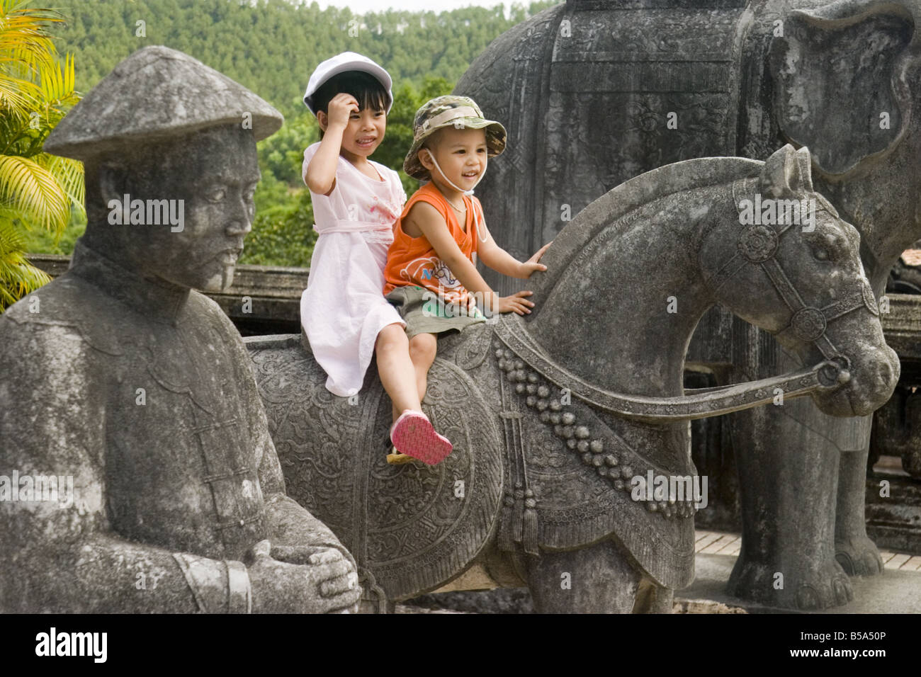 I bambini sul cavallo in pietra alla tomba dell'Imperatore Khai Dinh, tonalità, Vietnam Foto Stock