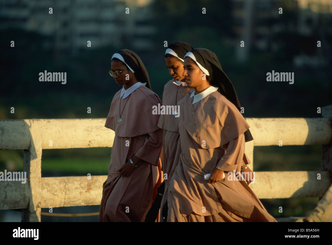 Le monache attraversando il fiume Mula, Pune, nello stato del Maharashtra, India Foto Stock