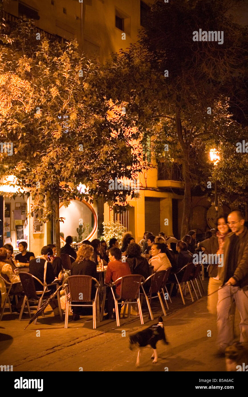 La gente seduta al di fuori di un affollato bar locale nel centro storico di El Carmen centro di Valencia Spagna Foto Stock