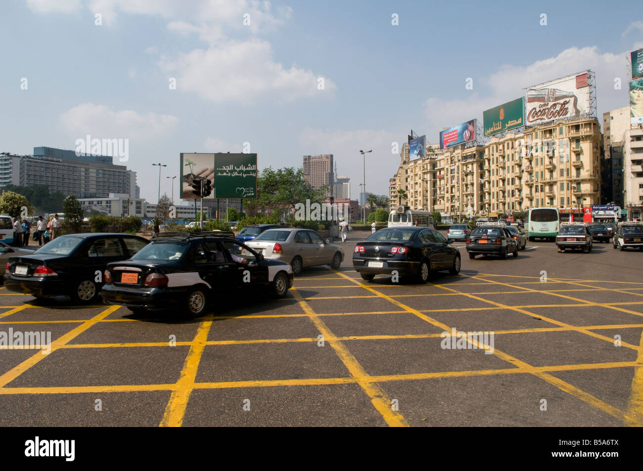 In funzione del traffico attraverso Piazza Tahrir, noto anche come martire piazza", una delle principali città pubblica piazza nel centro cittadino del Cairo, Egitto. Foto Stock