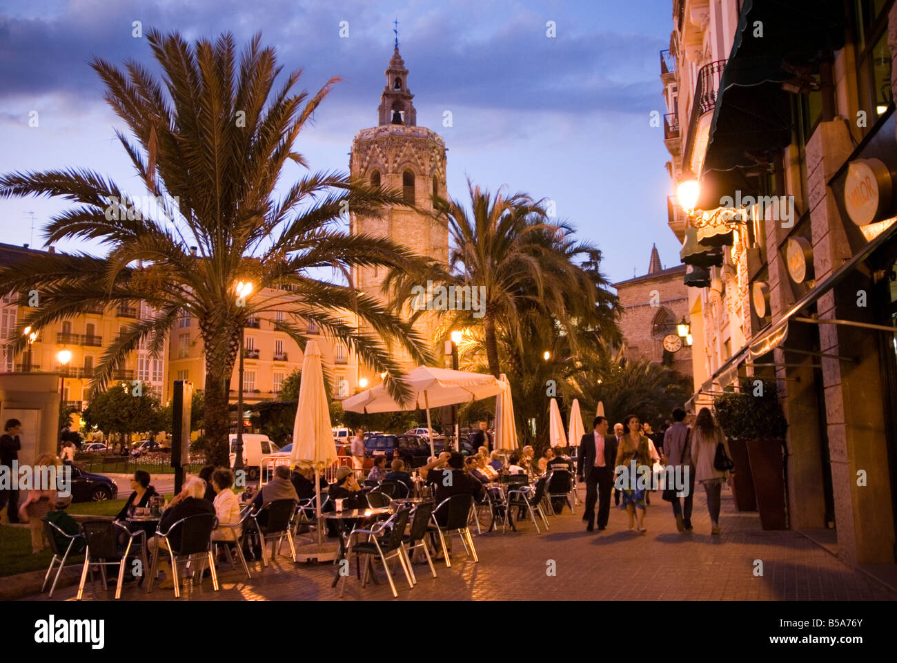 La gente seduta al di fuori di un affollato bar sulla Plaza de la Reina con veiw al Miguelete torre della cattedrale di El Carmen Valencia Spagna Foto Stock