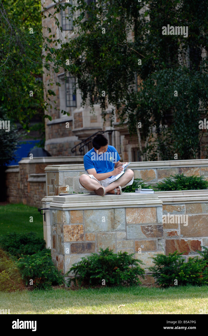 Asian studente lettura sul campus di Yale Foto Stock