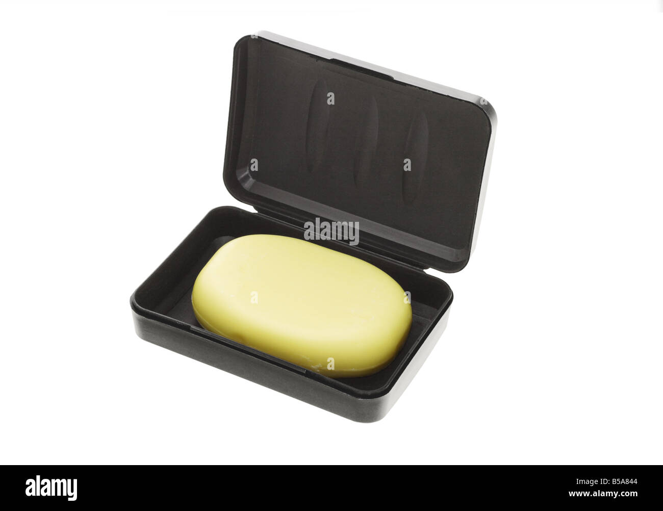 Barra di sapone giallo nel contenitore nero su sfondo bianco Foto Stock