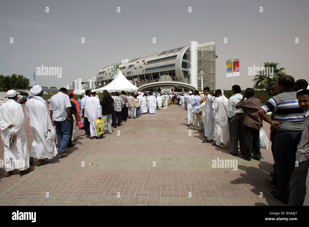 Gli uomini arabi in attesa in coda per il Nad Al Sheba cavallo di razza in corso, Dubai, Emirati Arabi Uniti Foto Stock