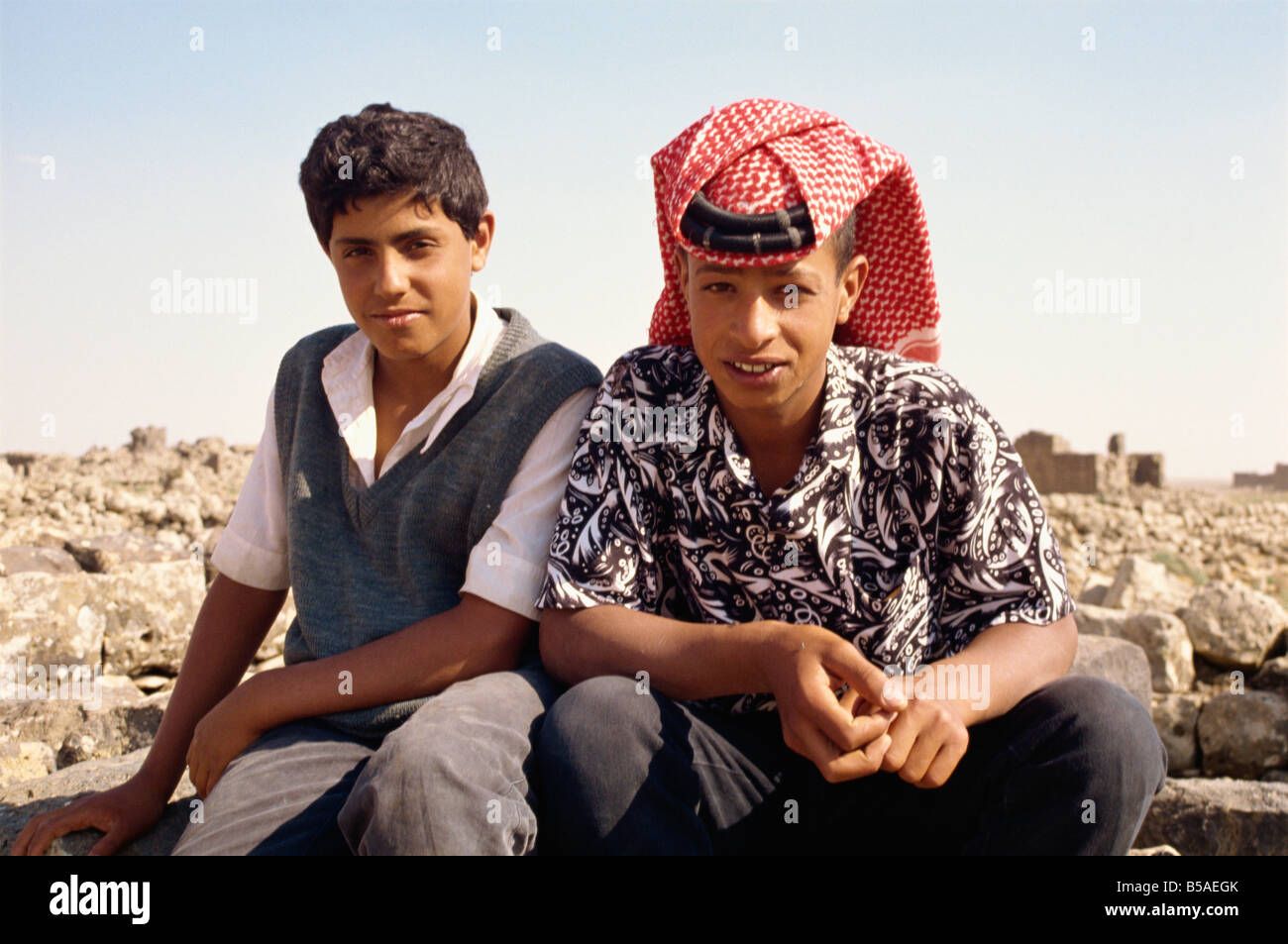 Ritratto di due giovani guide locali uno indossando il tradizionale headcloth presso le rovine di Umm al Jimal Giordania Medio Oriente Foto Stock