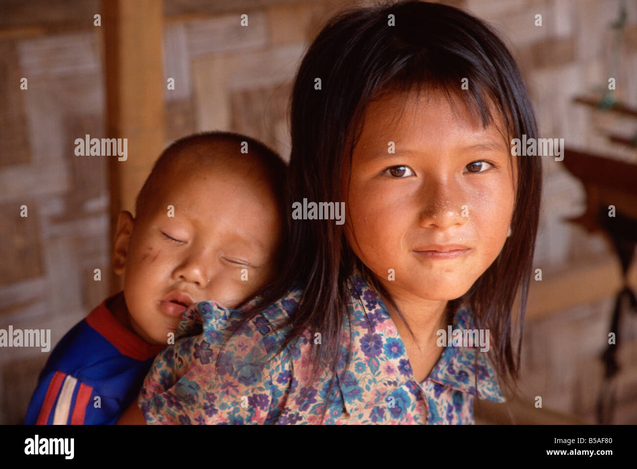 Ragazza Hmong portando il suo fratello, Laos, Indocina, sud-est asiatico Foto Stock