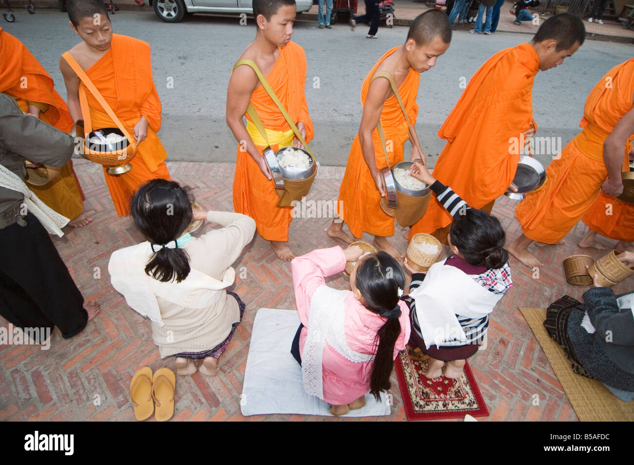 I monaci la raccolta di alimenti a 7am, Luang Prabang, Laos, Indocina, sud-est asiatico Foto Stock