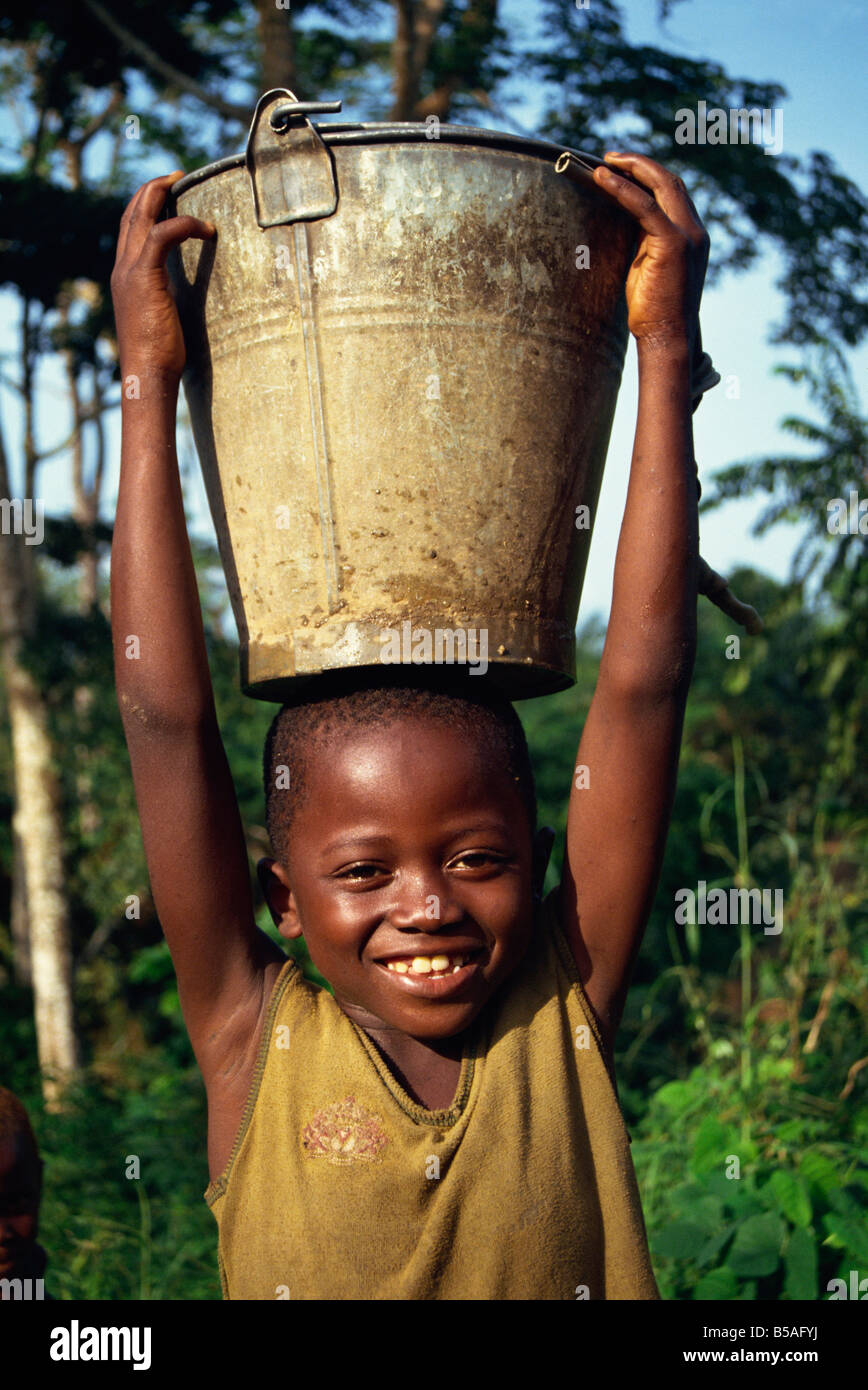 Ritratto di bambino portando acqua Liberia Africa L TAYLOR Foto Stock