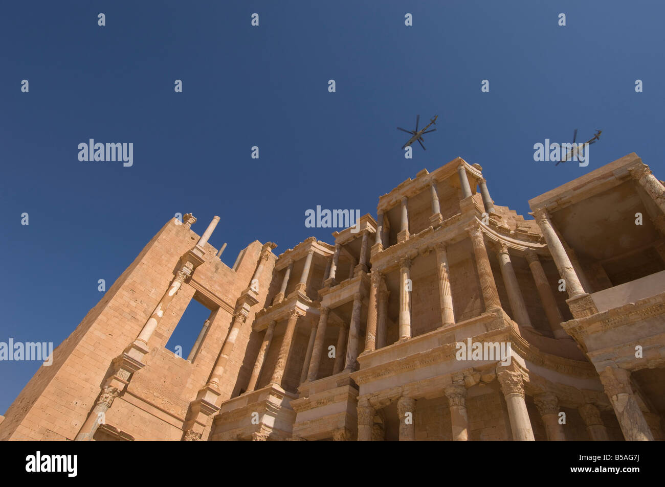 Elicotteri volare oltre il teatro romano, Sabratha sito romano, Sito Patrimonio Mondiale dell'UNESCO, Tripolitania, Libia, Nord Africa Foto Stock