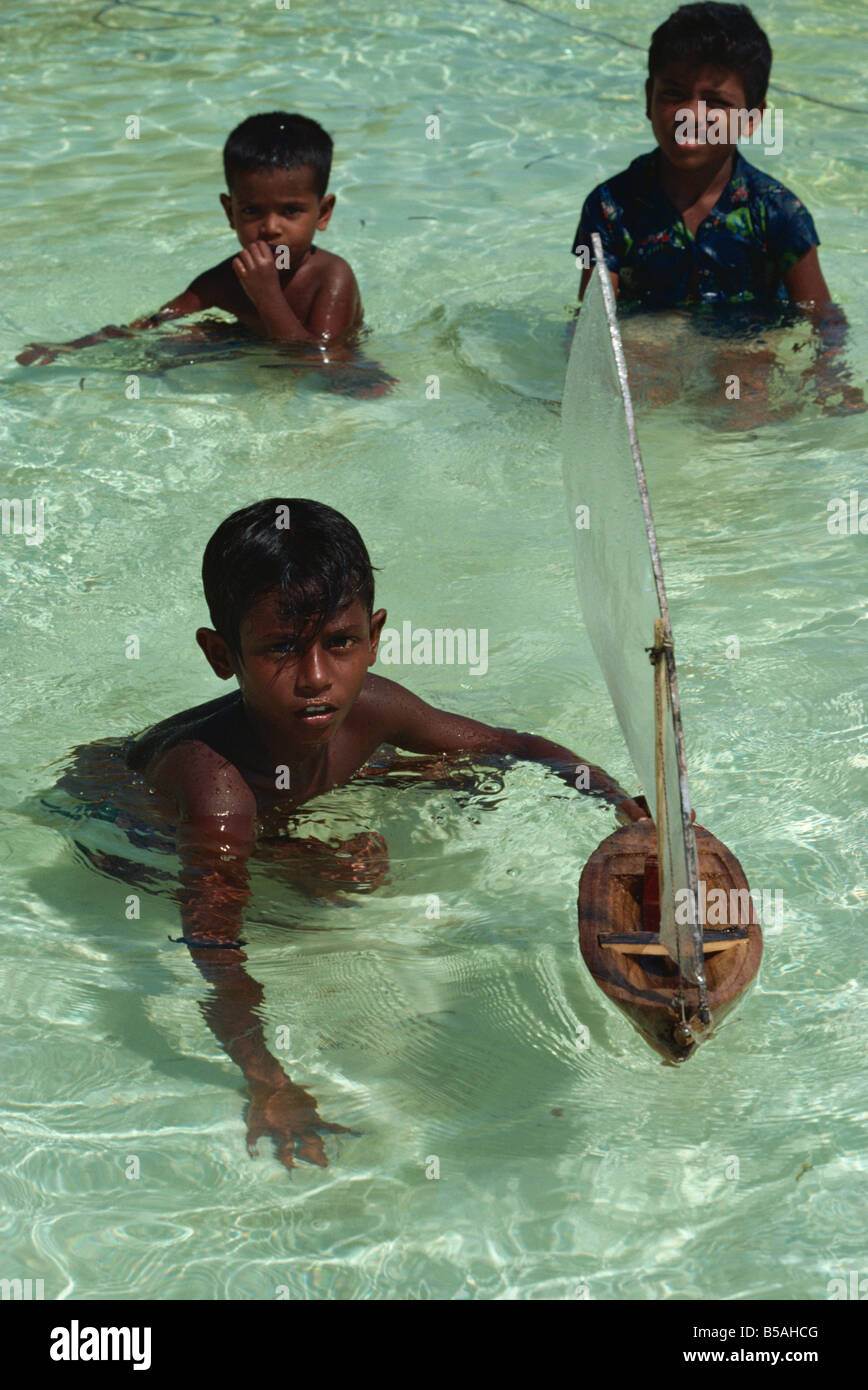 Ragazzi con barca giocattolo, Maldive, Oceano Indiano Foto Stock