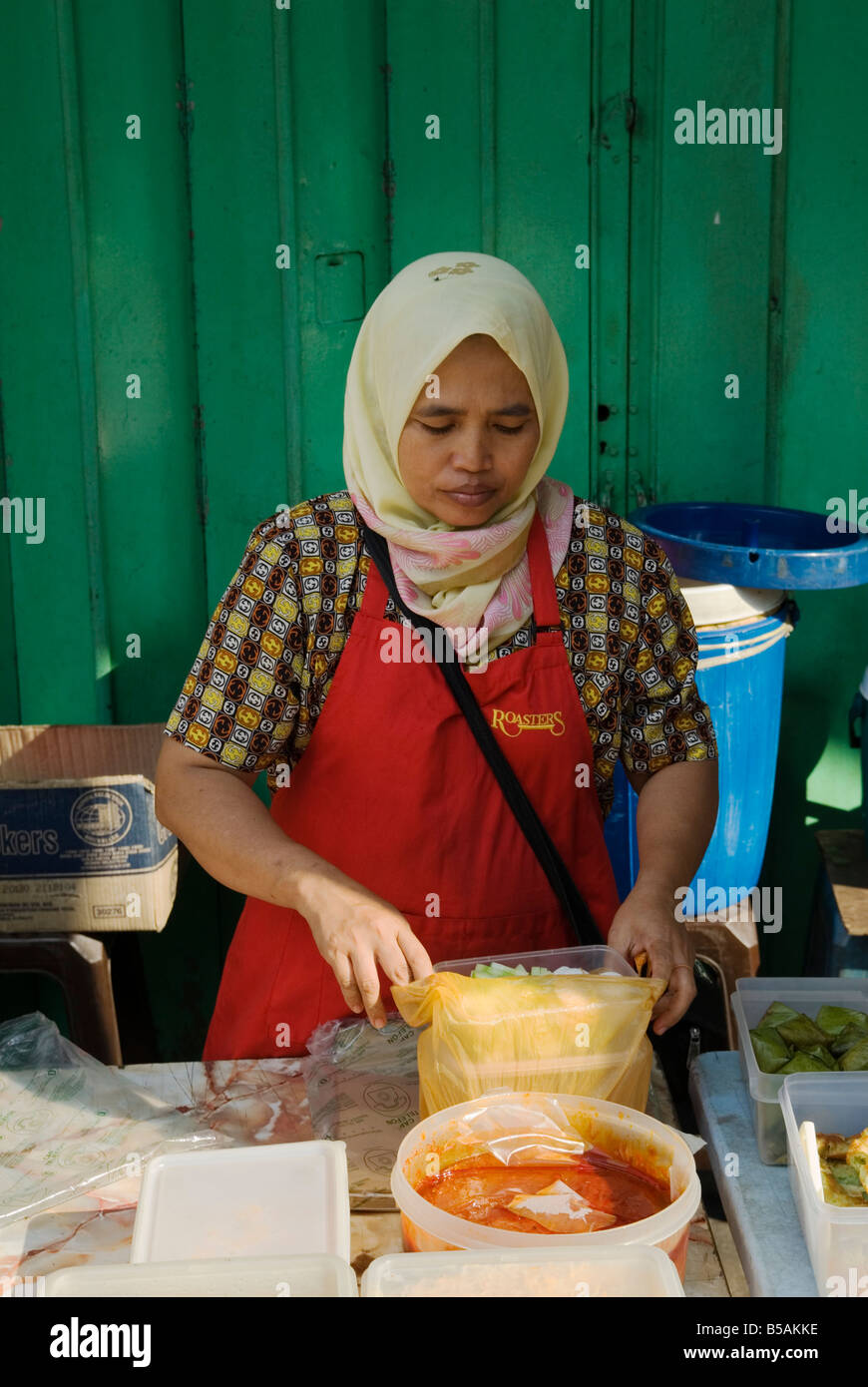 Un venditore ambulante prepara il cibo al suo lato strada stallo alimentare, Kuala Lumpur, Malesia Foto Stock