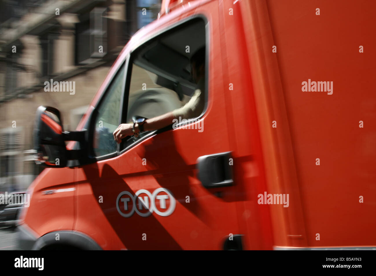 Arancio fast consegna tnt camion su strada in città città Foto Stock