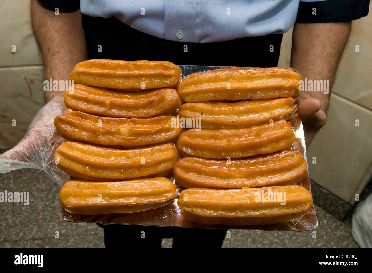 Pila di Dolce Delizia Tulumba o Bamiyeh fritte pasta pastella imbevuto di sciroppo semplice trovata in cucina Ottomana chiamato in Egitto balah ash-sham Foto Stock