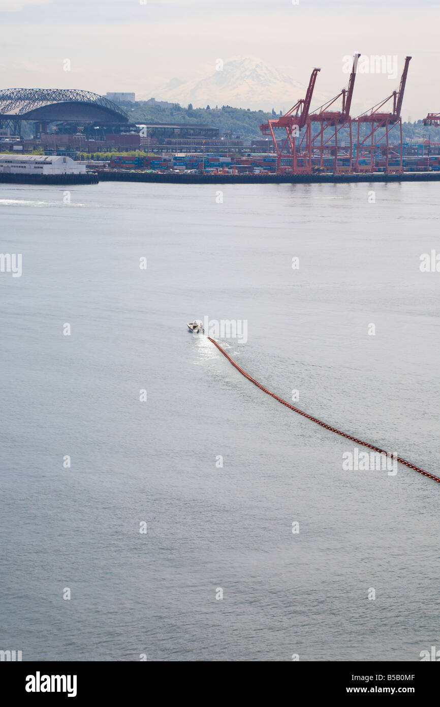 Rimorchiatore tira un contenimento di dispersioni dispositivo attraverso Elliot Bay a Seattle, Washington Foto Stock