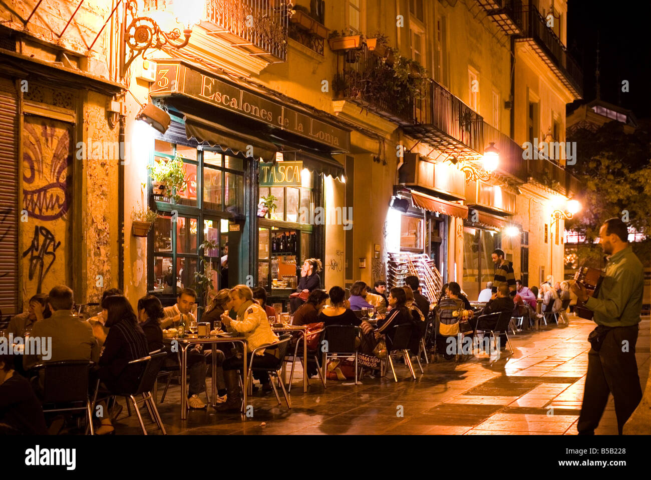 La gente seduta al di fuori dei bar di tapas bar Escalones de la Lonja nella storica El Carmen centro di Valencia Spagna Foto Stock