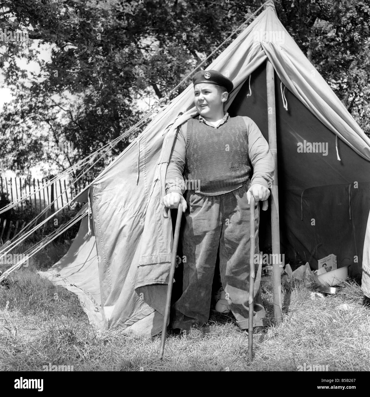 Disabilità e gioventù: Tommy Hoare il legless boy scout visto qui godendo camping, visto qui in piedi al di fuori della sua tenda. Luglio 1955 Foto Stock