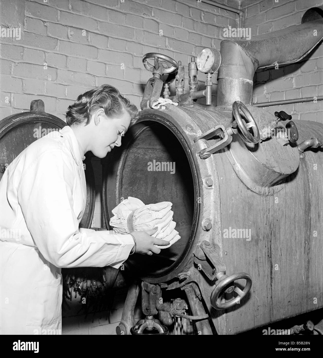 Medical Store: un medico ospedaliero nei negozi dove tute, camici, maschere e attrezzature utilizzati in sala operatoria vengono sterilizzati prima di essere ri-alimentato al teatro. 1954 Foto Stock