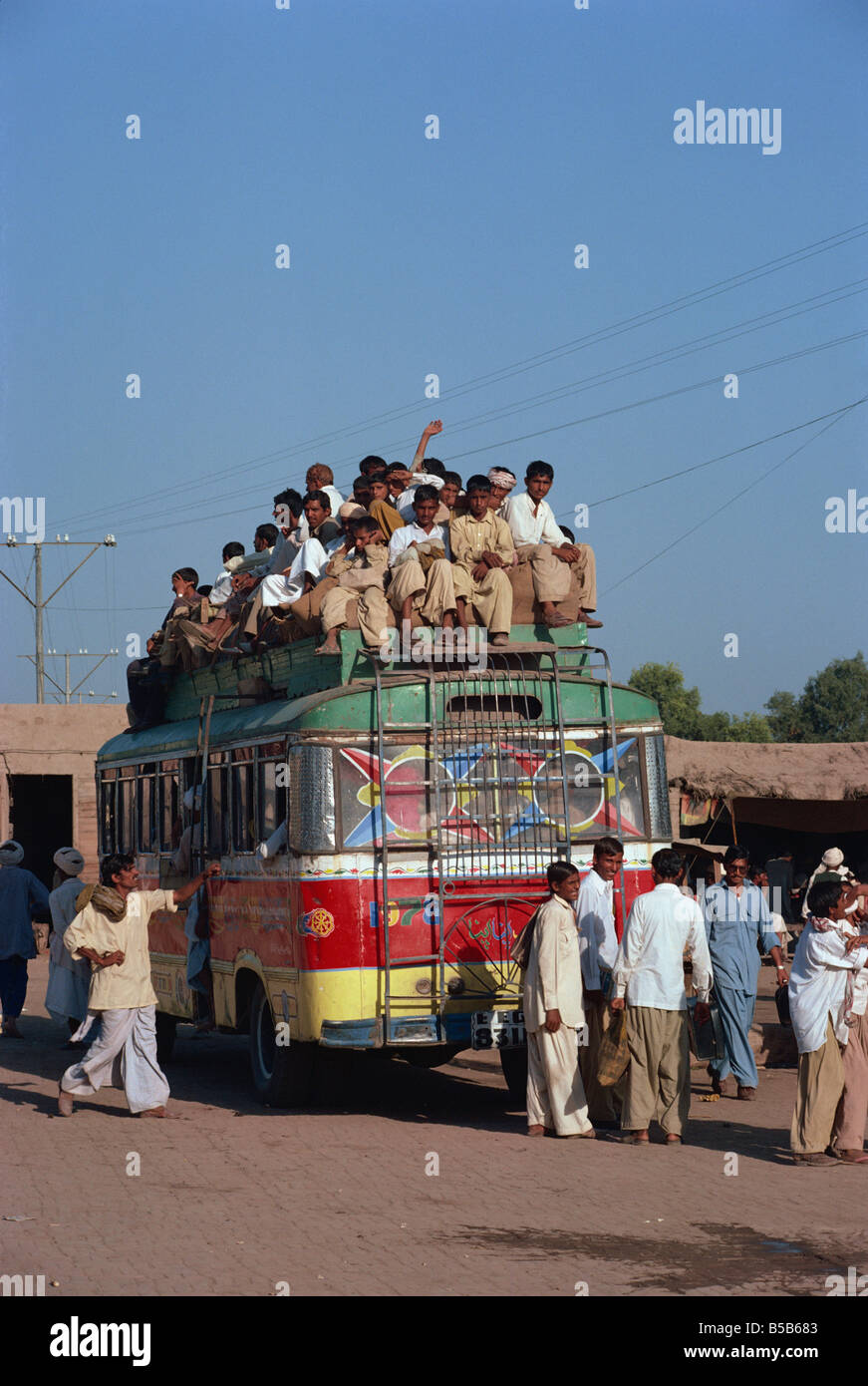 Bus sovraccarico con uomini a cavallo sul tetto vicino a Multan in Pakistan Foto Stock