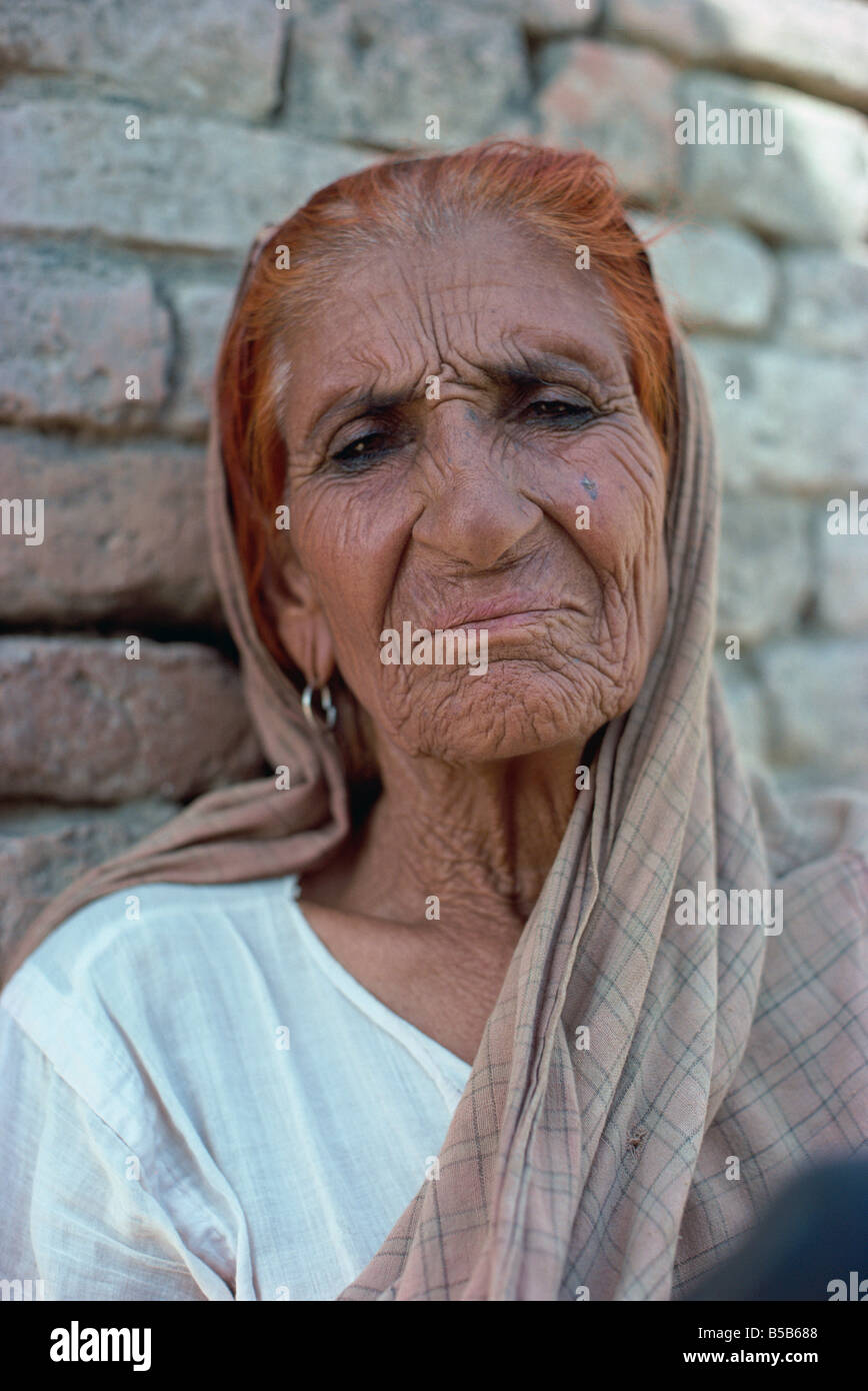 Ritratto di una donna anziana con i capelli tinti rosso con henné, ad Harappa, Punjab, Pakistan Foto Stock