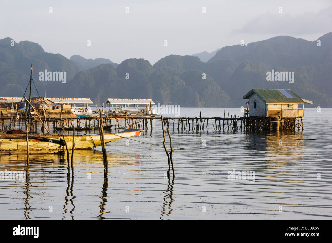 Di forma insolita colline costiere di Coron Island, e palafitte, Coron Town, Busuanga Island, Palawan Provincia, Filippine, Asia Foto Stock