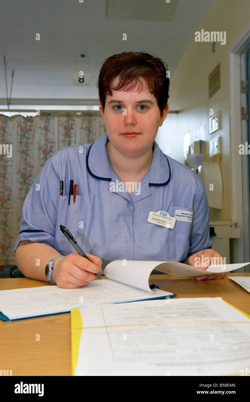 Uno staff giovane infermiere alla sua scrivania Foto Stock