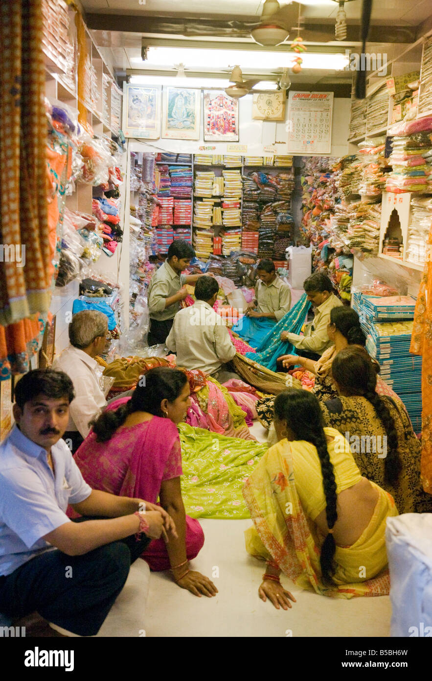 Le donne lo shopping ed acquisto di sari in un sari shop nel mercato Kinari, Vecchia Delhi India Foto Stock