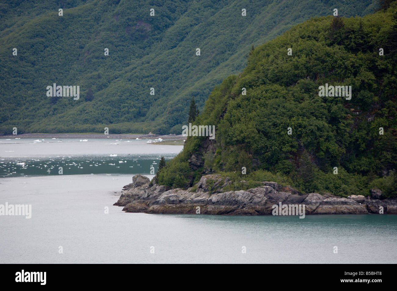 Costa rocciosa di un passaggio interno isola e flusso di ghiaccio nelle acque vicino ghiacciaio Hubbard in Alaska Foto Stock