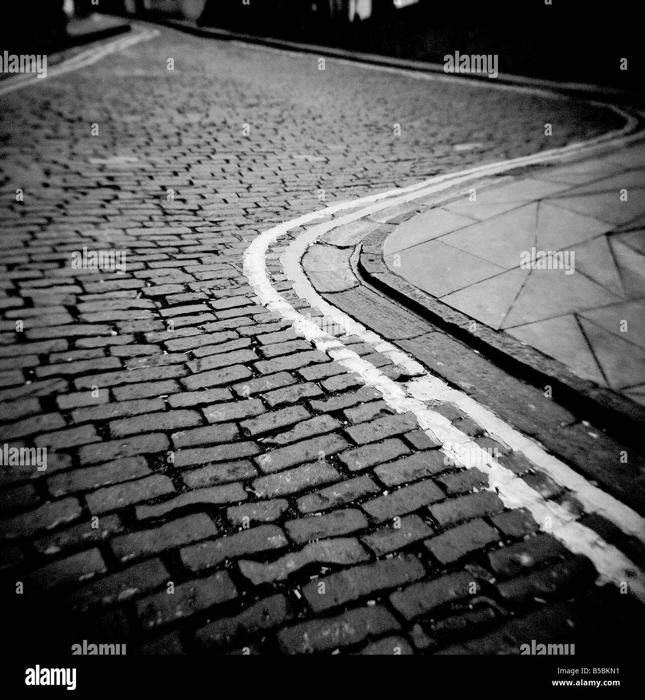 Avvolgimento strada di ciottoli con doppio giallo n linee di parcheggio, Edimburgo, Scozia, Regno Unito Foto Stock