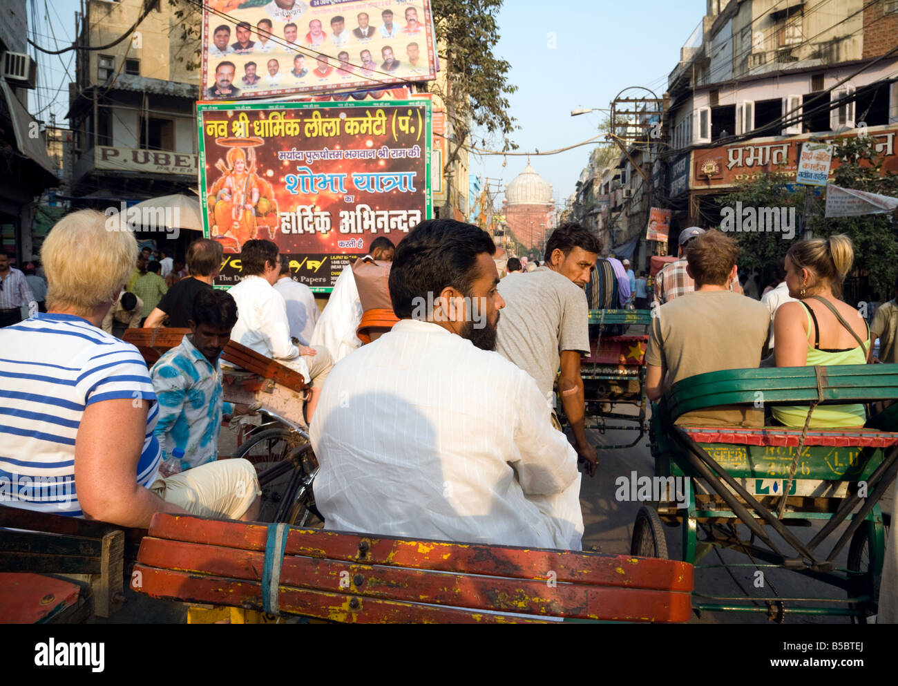 I turisti e i locali di viaggio in Old Delhi in risciò bicicletta Foto Stock