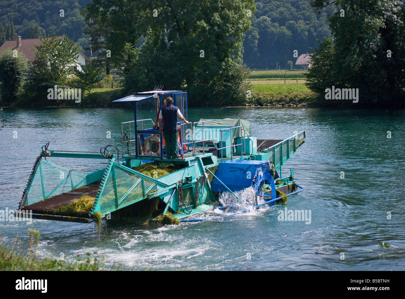Un appositamente progettato barca scoop invasiva piante acquatiche fuori del Fiume Thielle, Svizzera Foto Stock