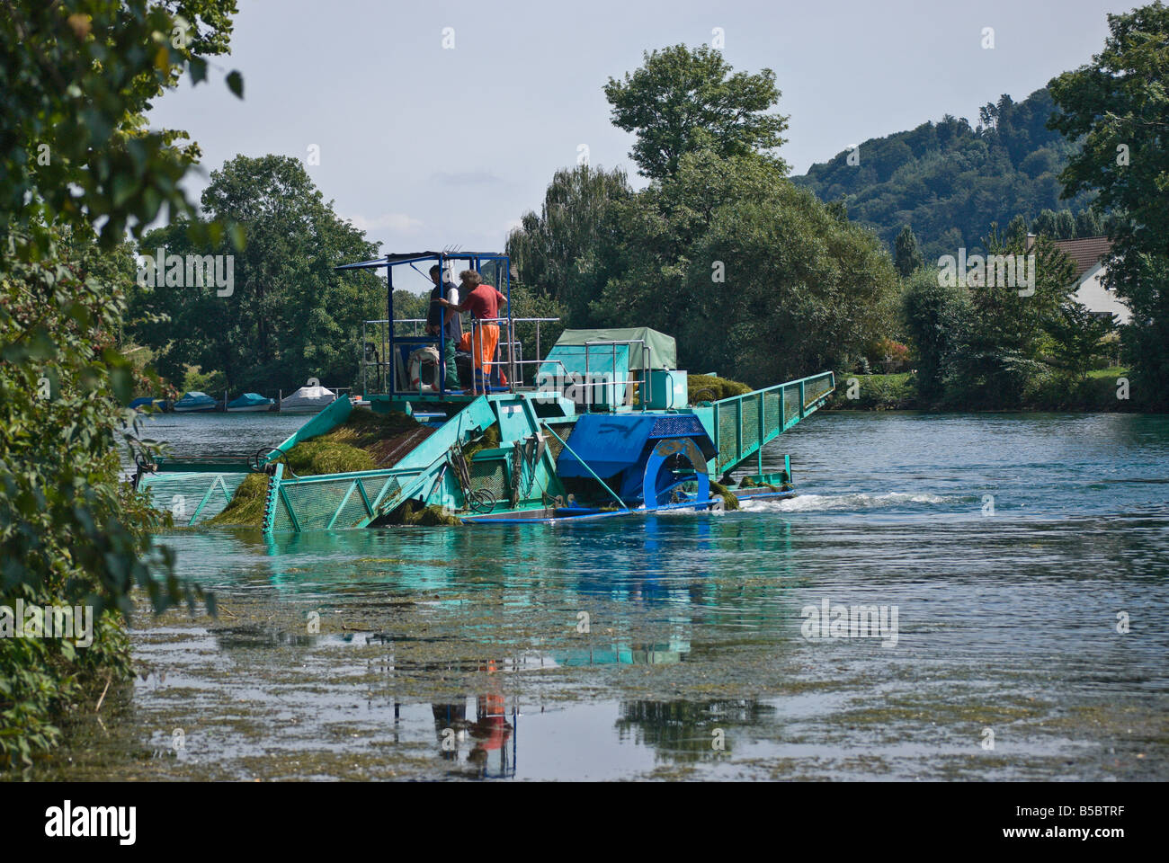 Un appositamente progettato barca scoop invasiva piante acquatiche fuori del Fiume Thielle, Svizzera Foto Stock