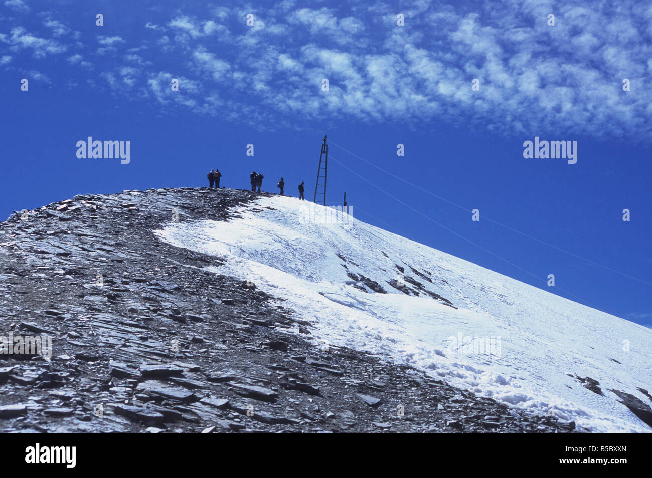 Escursionisti che si avvicinano alla cima del monte Chacaltaya, parte del ghiacciaio in recidiva sulla destra, Cordillera Real, Bolivia Foto Stock