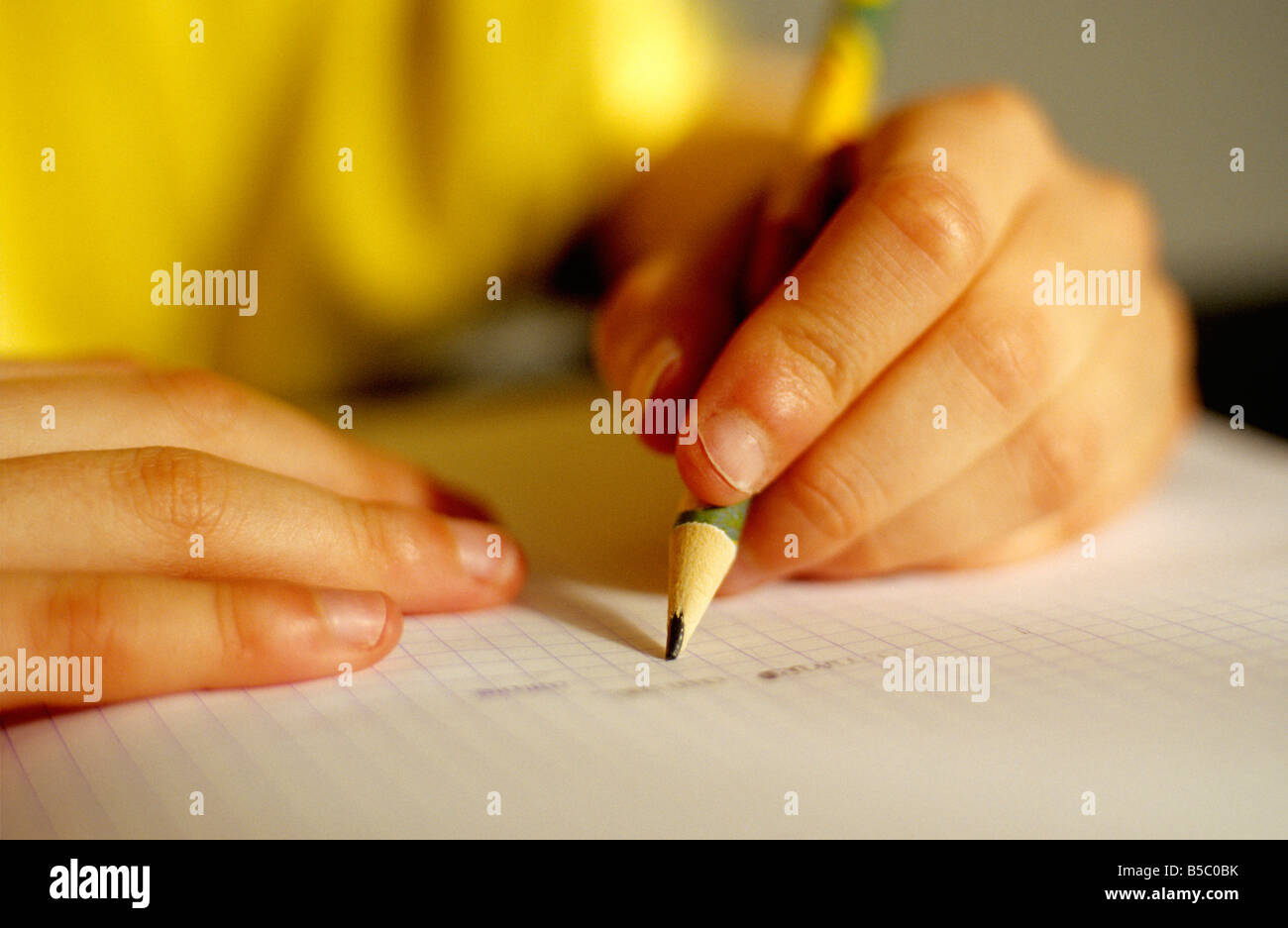 Le mani del giovane mancino bambino facendo i compiti di scuola Foto Stock