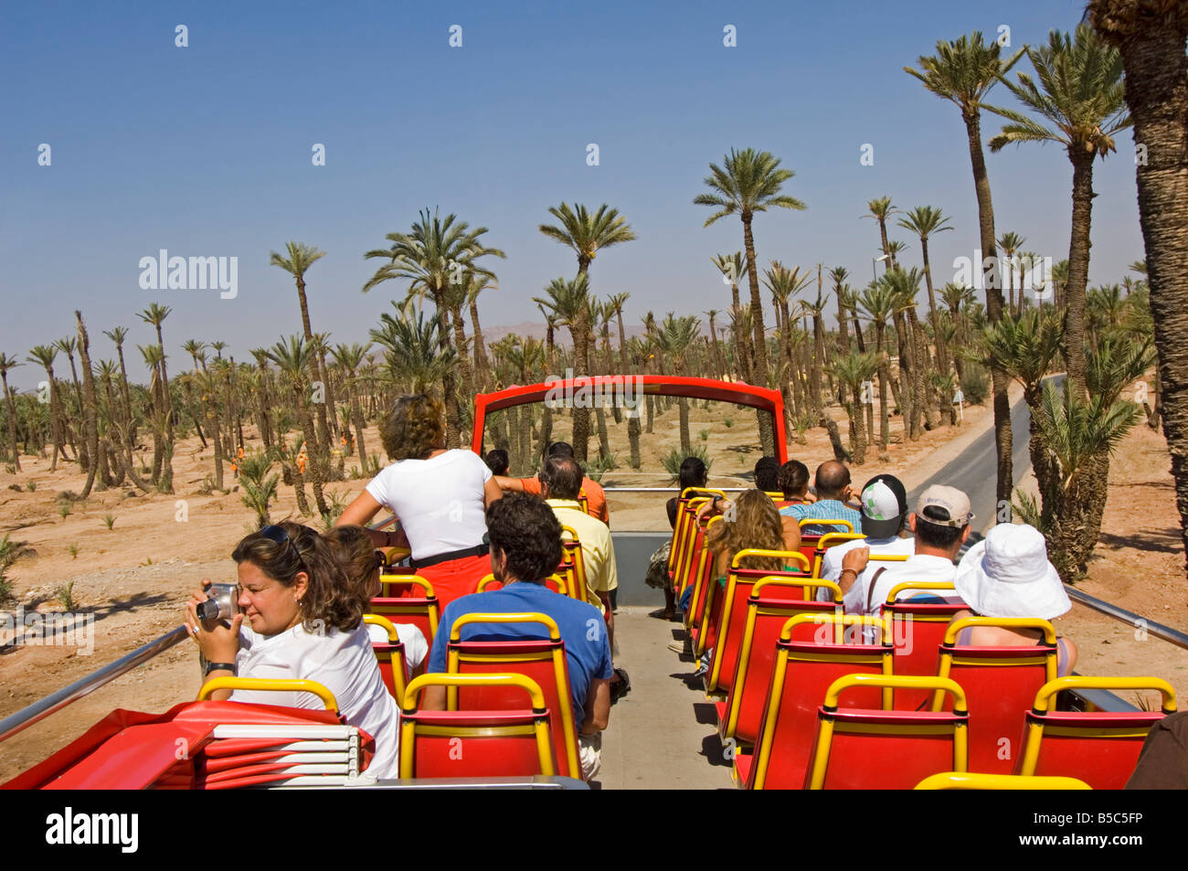 Il piano superiore di un organizzato autobus turistico tour intorno a Marrakech che viaggiano attraverso 'La Palmeraie' - Il Palm Grove. Foto Stock