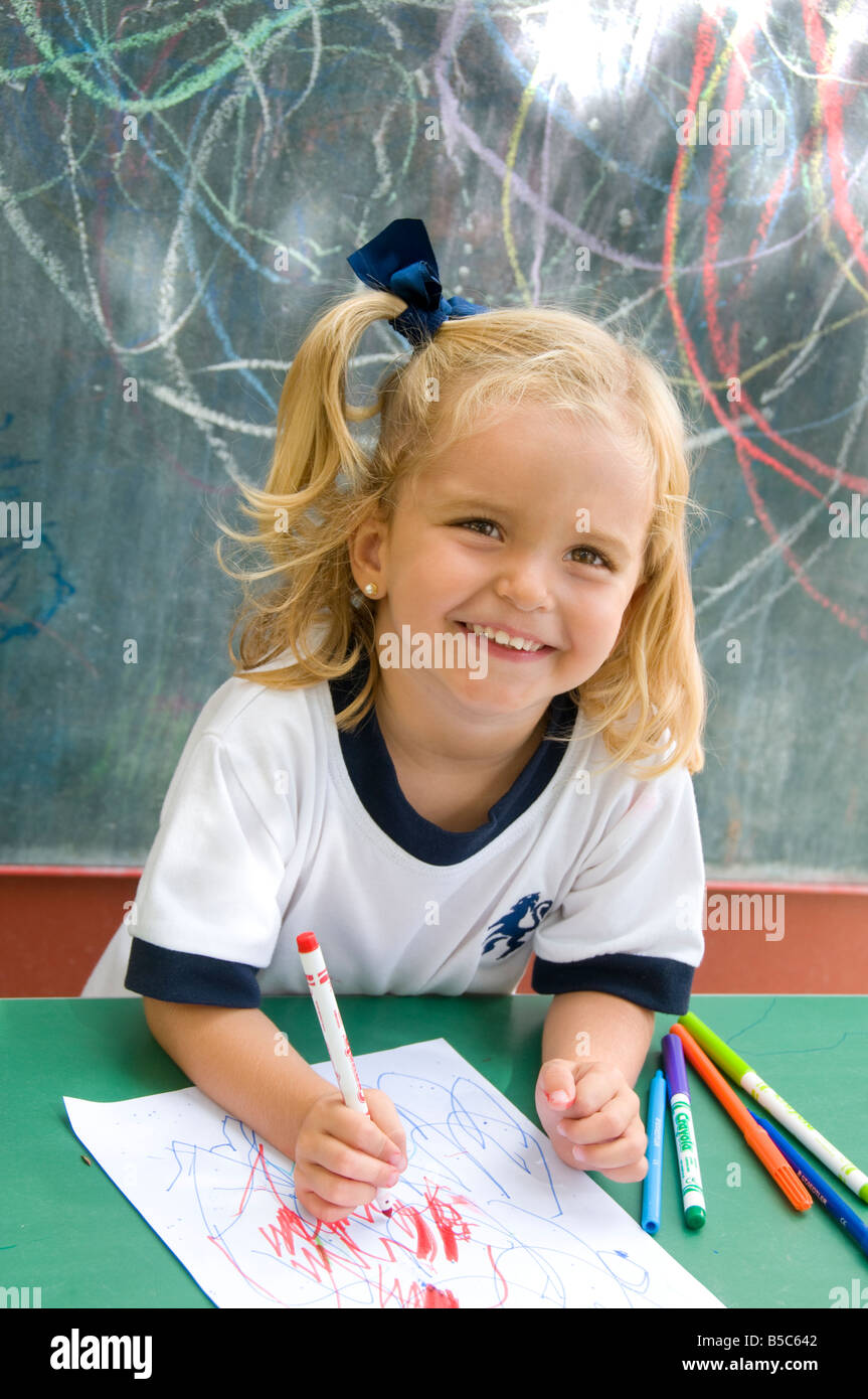Felice di ridere attraente ragazza infantile al di fuori nella soleggiata kindergarten scuola imparare a formare e disegnare forme Foto Stock