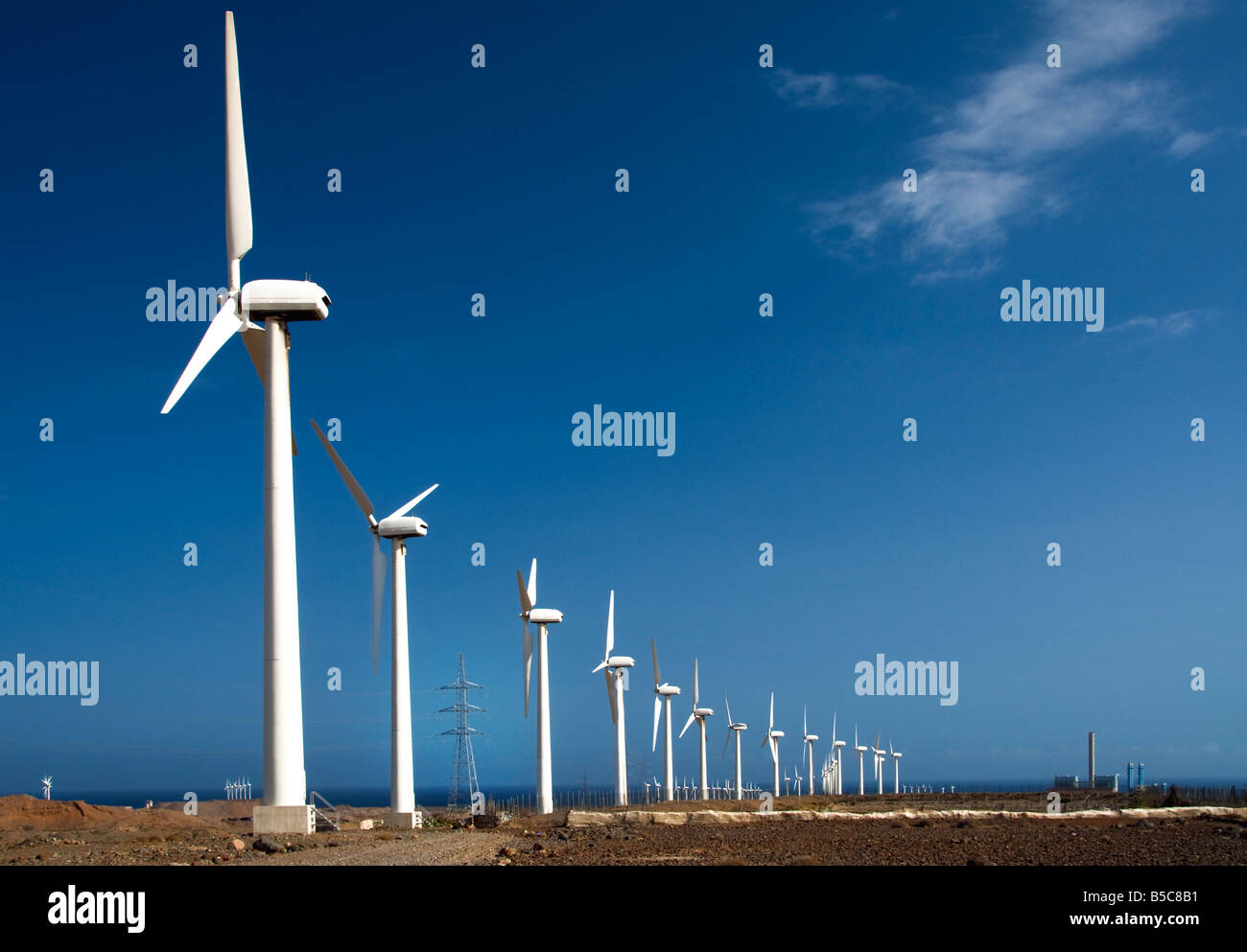 Le turbine eoliche con elettricità pilone e power station sulla linea costiera in Isole Canarie Spagna Foto Stock