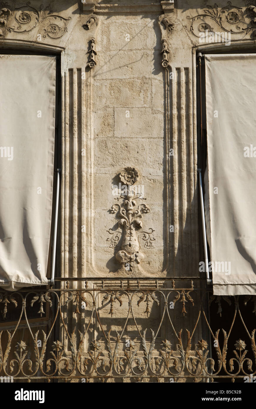 White tende sono tirato giù sopra le finestre di un bellissimo edificio in arenaria nella vecchia città di Montpellier. Foto Stock