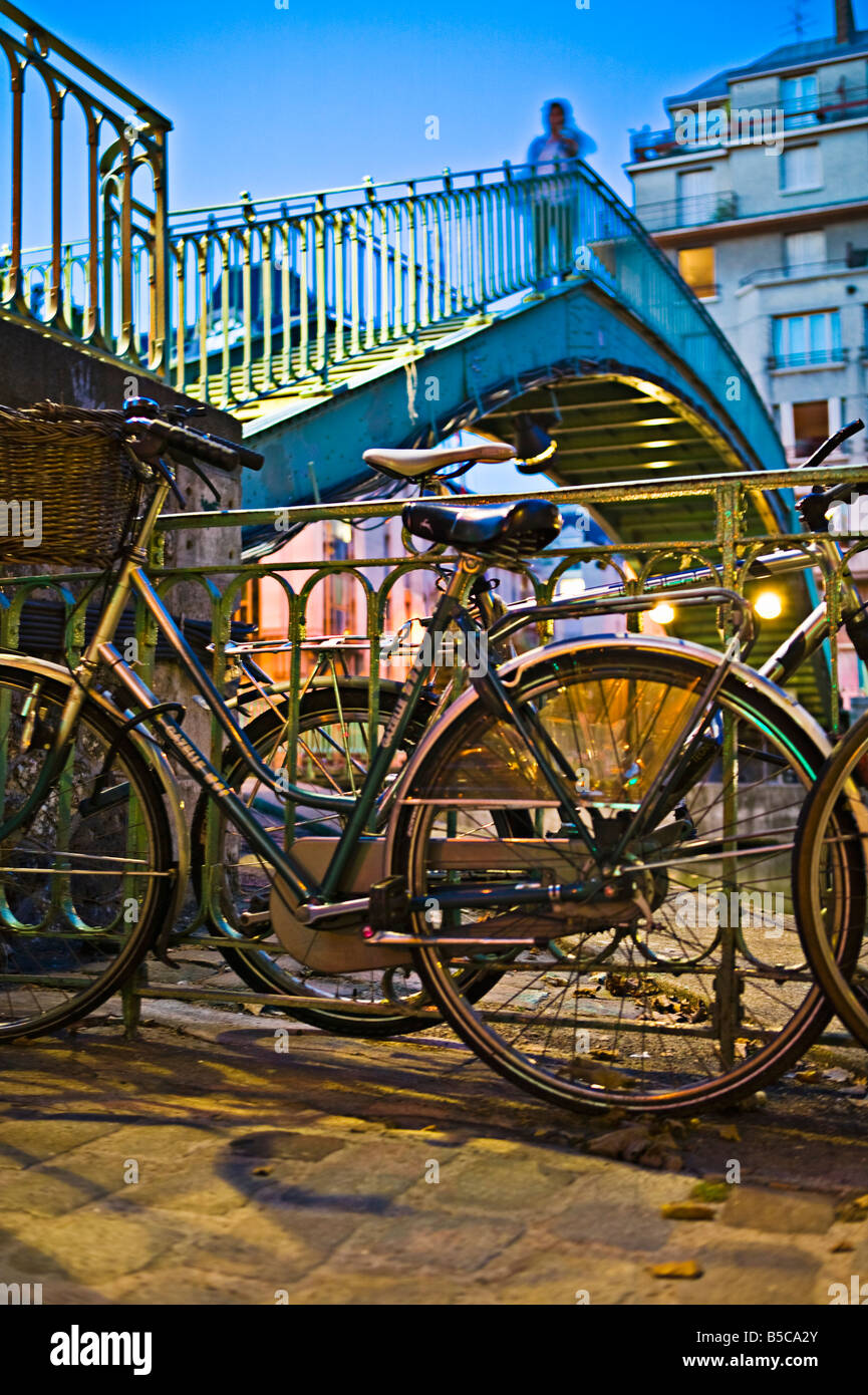 Underview di un ponte metallico con le biciclette in primo piano nel crepuscolo Foto Stock