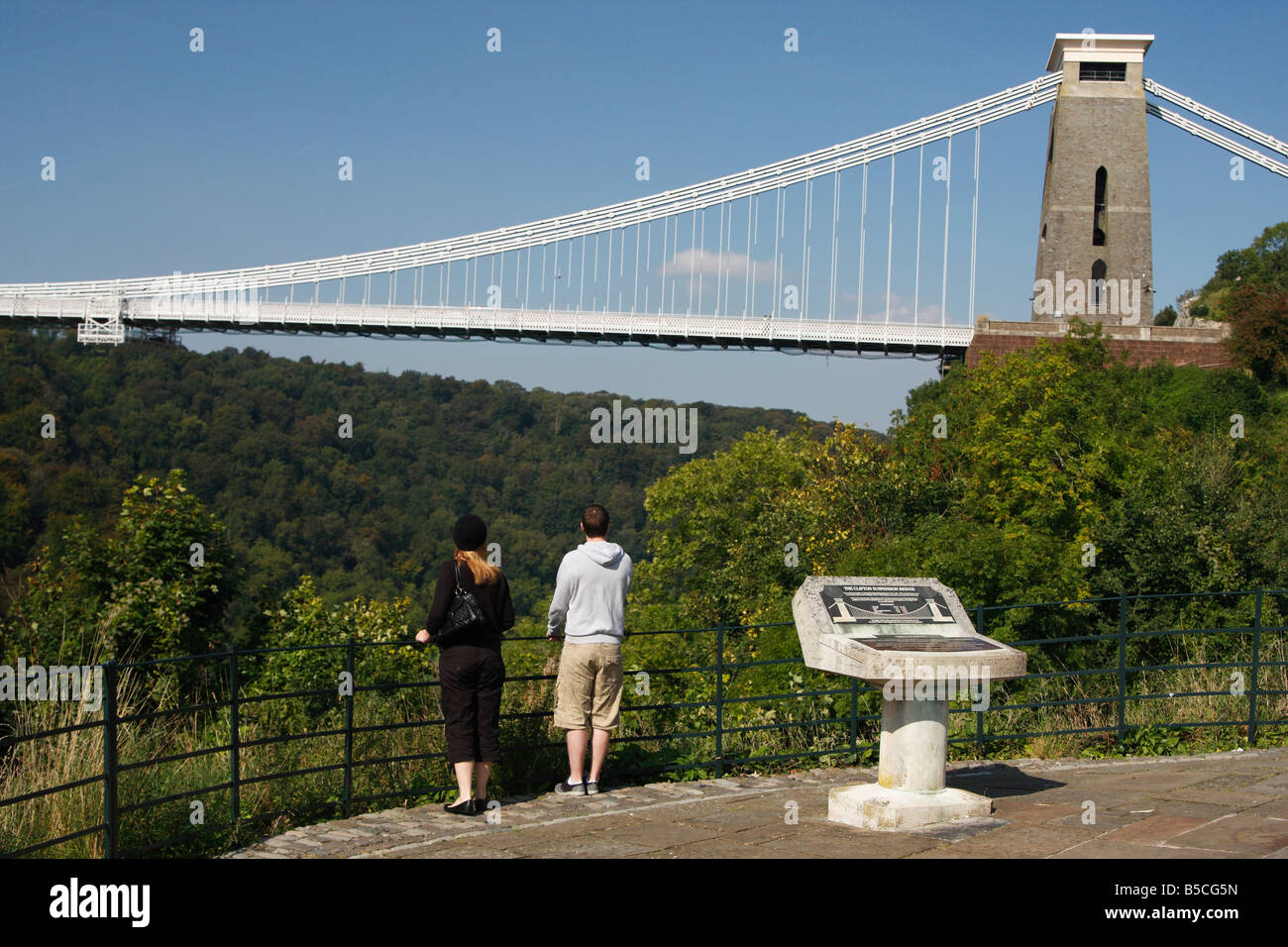 L uomo e la donna stava guardando il famoso [Clifton Suspension Bridge] da "la vedetta" su [Avon Gorge], Bristol, Inghilterra, Regno Unito Foto Stock