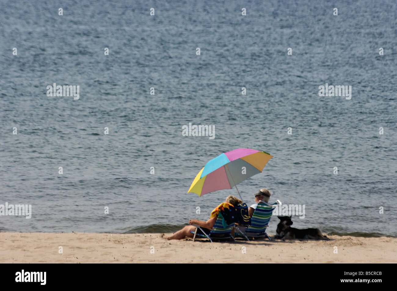 Due donne rilassanti sul Lago Michigan spiaggia con il loro cane Grand Haven Michigan Foto Stock