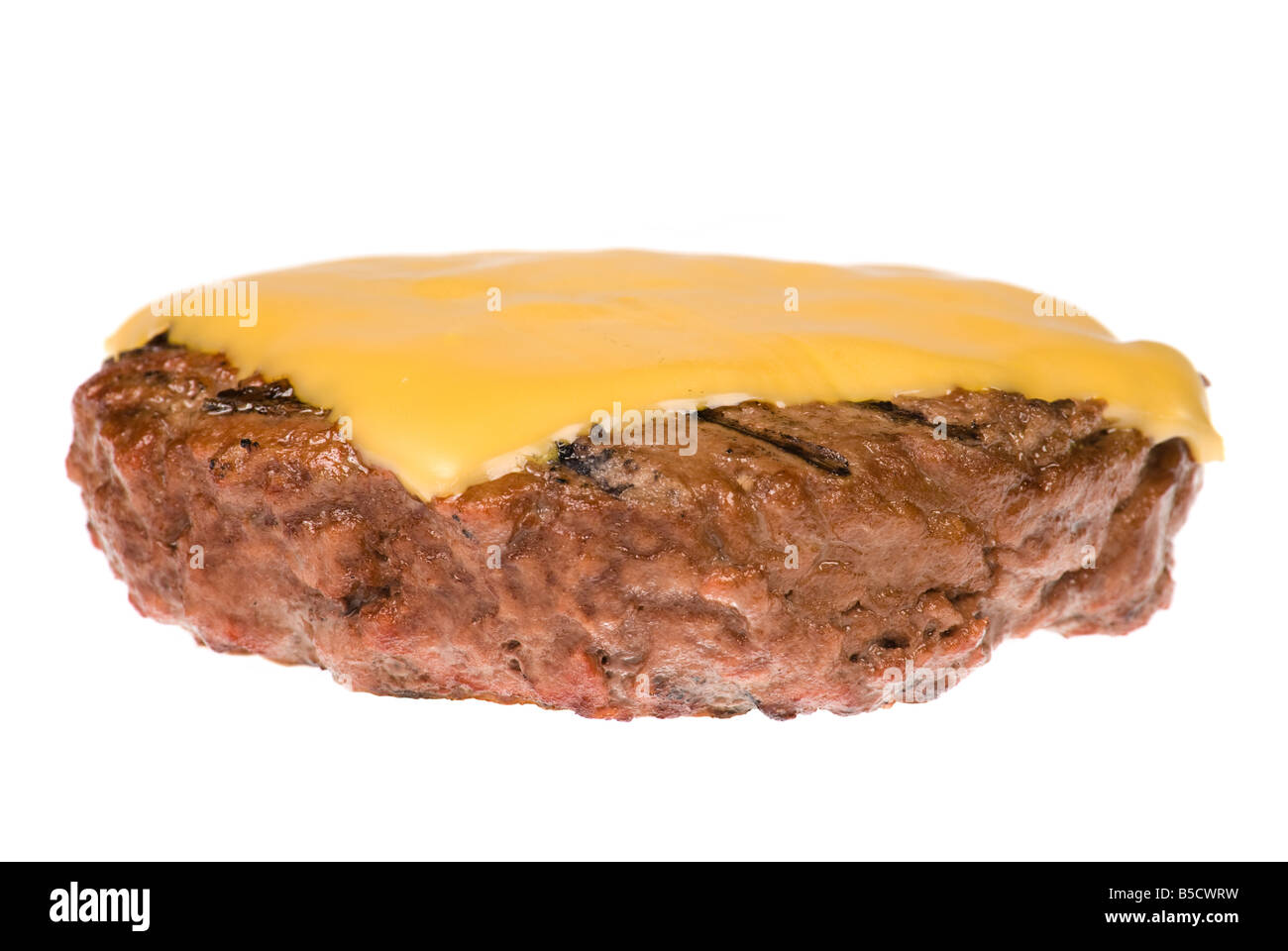 Una spessa succosa hamburger patty con un fuso fetta di formaggio appena cucinata su un barbecue e isolato su bianco Foto Stock