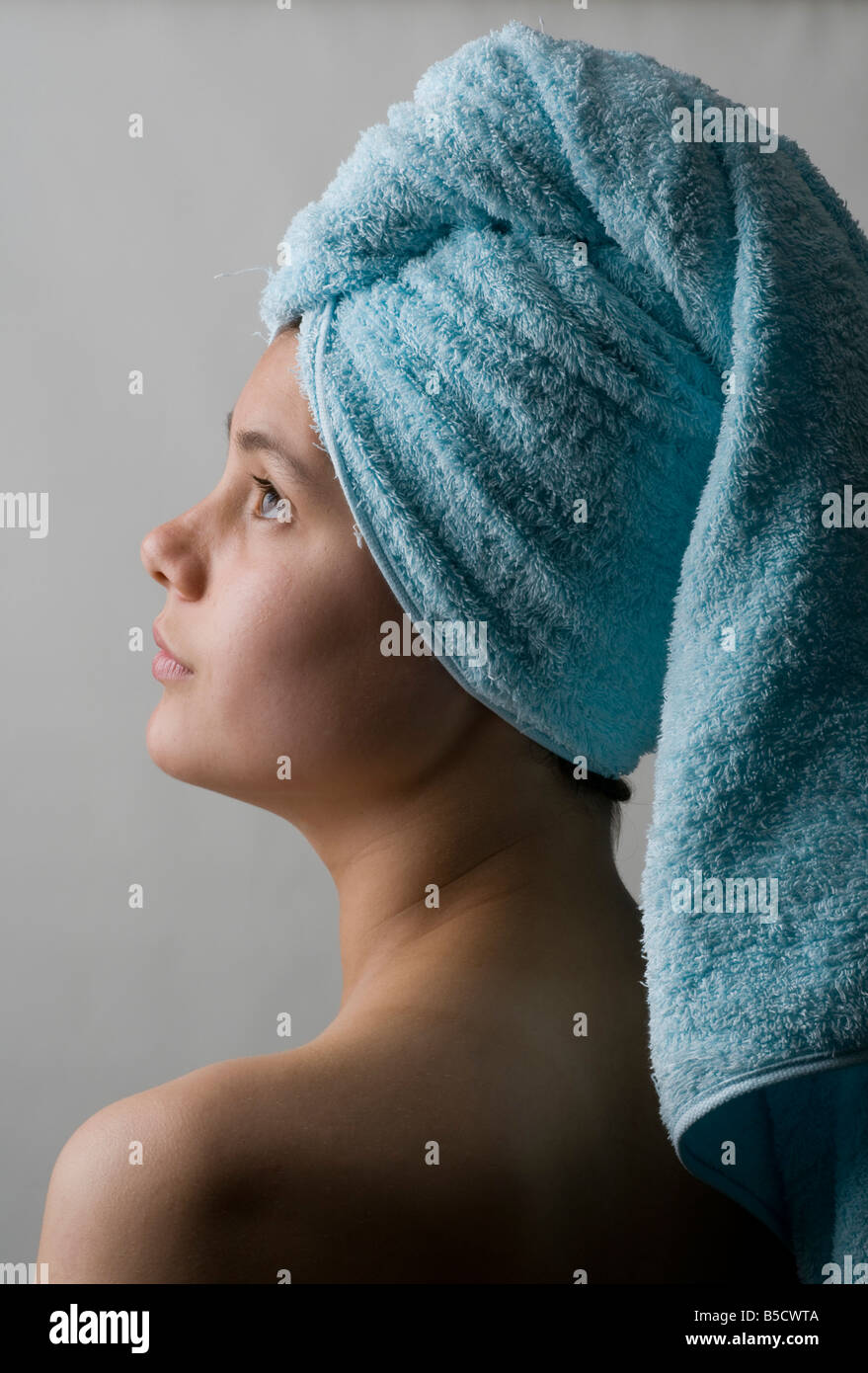 Piuttosto giovane adolescente con la testa avvolta in un asciugamano dopo il lavaggio i capelli Foto Stock